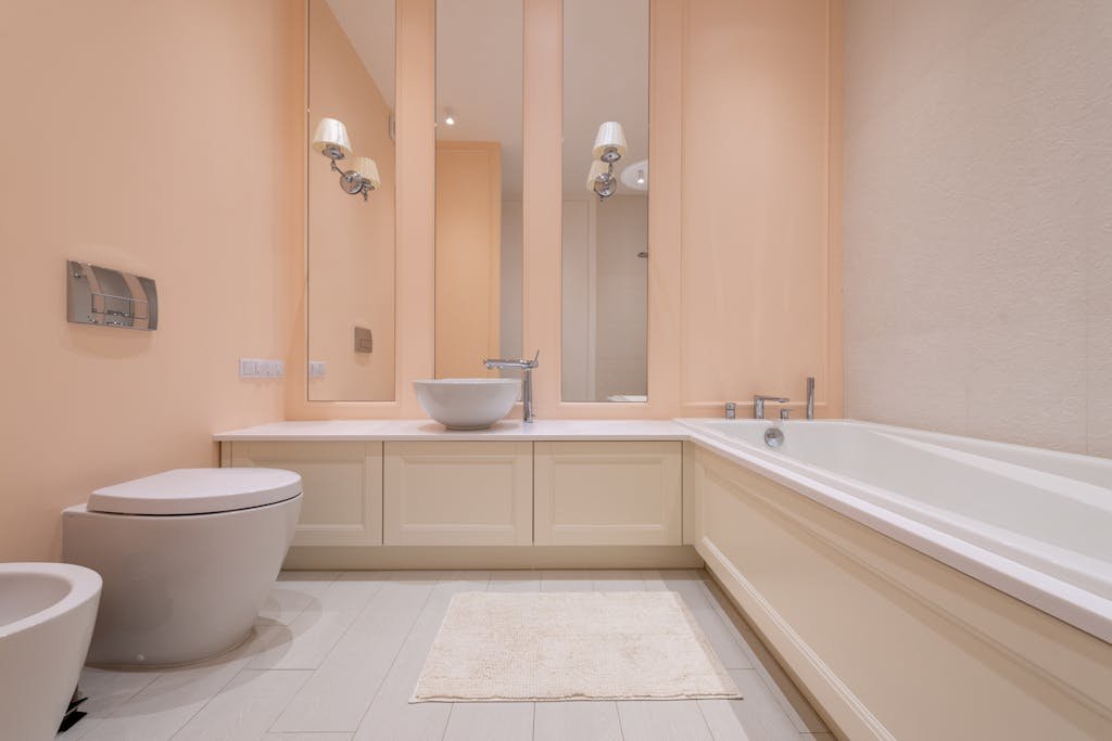 A spacious and elegant bathroom featuring a modern minimalist design with neutral tones.