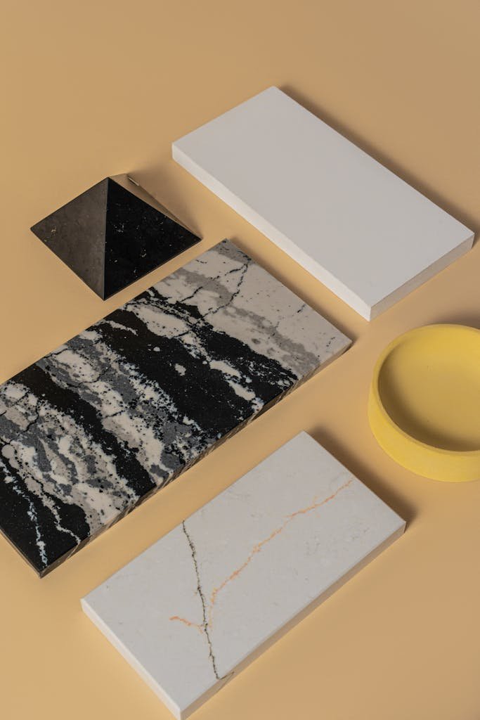 Flat lay of geometric tiles and shapes on beige background showcasing minimalist design.
